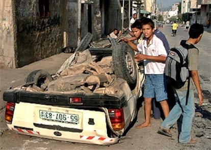 Unos niños palestinos miran el estado en el que quedó el coche bomba desactivado cerca de Nablús.