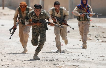 La alianza de las Fuerzas Democráticas Sirias (SDF) liderada por los kurdos arrebata al ISIS el control de Raqqa. En la imagen, combatientes kurdos avanzan el lunes por una calle de Raqa, en septiembre de 2017.