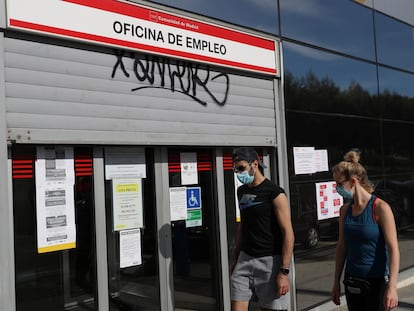 Dos jóvenes pasan ante una ofician de empleo este martes en Madrid.