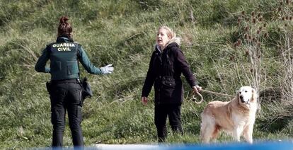 A Civil Guard officer informs a dog owner of the lockdown rules.
