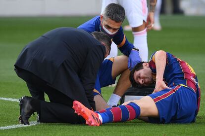 Messi recibe atención médica después de una jugada.