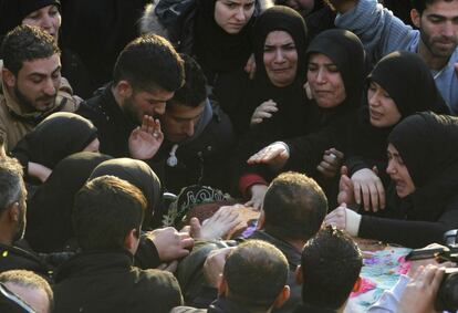 Familiares de Malak Zahwi, que murió en el atentado con coche bomba que tuvo lugar en Beirut, lloran sobre su ataúd durante su funeral (Líbano).