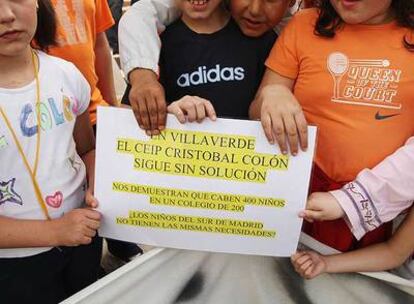 Varios niños que participaron en la manifestación de ayer enseñan una hoja con las denuncias sobre su colegio.