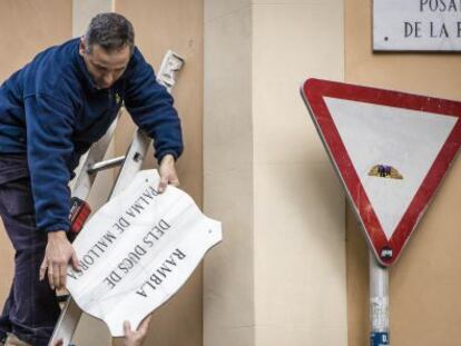 Un operario retira la placa de la calle de Los duques de Palma de Mallorca, el pasado febrero.