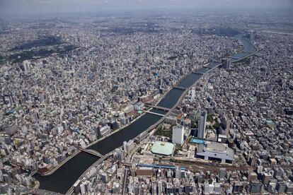 Vista aérea el río Sumida y el horizonte de la ciudad de Tokio (Japón). El Comité Organizador de los Juegos Olímpicos de Tokio ha notificado este domingo que dos atletas alojados en la Villa Olímpica han dado positivo en coronavirus. El total de contagiados registrados desde principios de mes relacionados con el gran evento internacional, que comenzará en menos de una semana, asciende a 47 tras confirmarse ayer otros 15 nuevos casos, uno de ellos detectado en la propia Villa Olímpica.