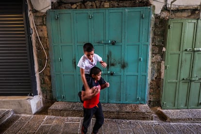 Dos niños juegan frente una de las muchas tiendas cerradas dentro de la ciudad vieja de Jerusalén. 