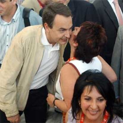 Zapatero saluda a una militante socialista en los pasillos del Palacio de Congresos de Madrid.