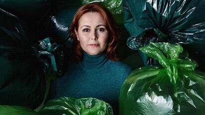 María Gallay surrounded by trash bags.