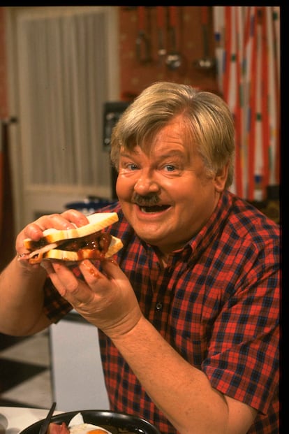 Benny Hill se come un sandwich durante un momento del rodaje de la serie en 1986.