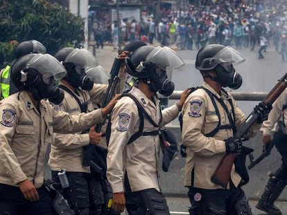 Agentes da Guarda Nacional Bolivariana bloqueiam a passagem de manifestantes em abril.