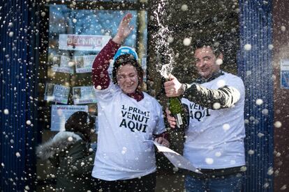 Laura, propietaria de la administración de la calle Guipúzcoa de Barcelona, y su marido celebran el primer premio del sorteo de la lotería de Navidad del 22 de diciembre.