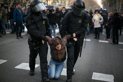 Grupos de activistas, muchos de ellos de los CDR, han llevado a cabo decenas de cortes de carreteras y calles en las primeras horas de la huelga general en Cataluña. En la imagen, agentes de los Mossos d'Esquadra desalojan a una manifestante que de la Gran Via de Barcelona.