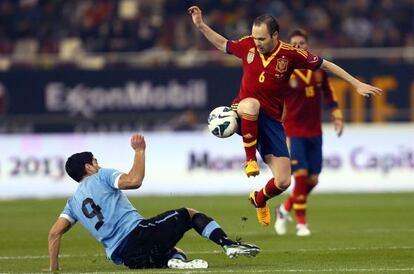 Iniesta regatea a Luis Suárez.