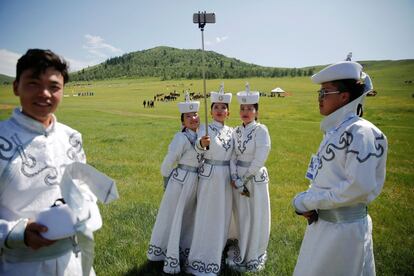 Varios artistas vestidos con trajes tradicionales se hacen un selfie mientras esperan la llegada de las delegaciones para una actuación en el tradicional festival nómada de Naadam durante la cumbre Asia-Europa (ASEM) en las afueras de Ulán Bator (Mongolia), el 15 de julio de 2016.