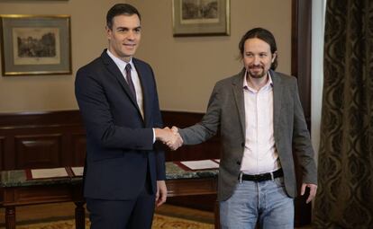 Caretaker prime minister Pedro Sánchez shakes hands with Unidas Podemos leader Pablo Iglesias.