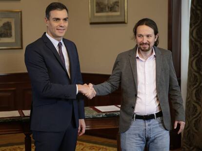 Caretaker prime minister Pedro Sánchez shakes hands with Unidas Podemos leader Pablo Iglesias.