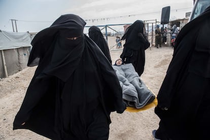 As jihadistas sírias e iraquianas desfrutam de maior liberdade de movimento do que as jihadistas estrangeiroas e têm um mercado no campo familiar do ISIS em Al Hol, no nordeste da Síria. Na imagem, elas transferem uma menina doente para ser tratada no hospital de campo, em 24 de outubro de 2019.