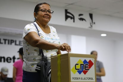 Una mujer introduce su voto en una urna durante una consulta popular este domingo, en Caracas (Venezuela). 
