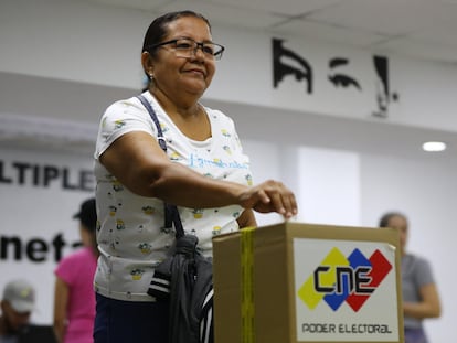 Una mujer introduce su voto en una urna durante una consulta popular este domingo, en Caracas (Venezuela).