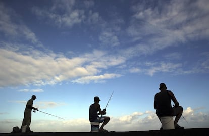 Tres hombres pescan hoy en el malecón de La Habana, pocas horas después de difundirse la noticia de la muerte de Fidel Castro.