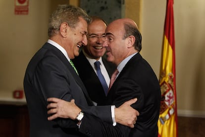 El presidente del Congreso, Jesús Posada, saluda al ministro de Economía, Luis de Guindos. Detrás, el presidente del Senado, Pío García Escudero.