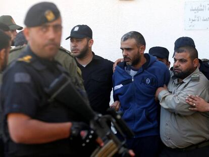 Fuerzas armadas en Gaza escoltan a uno de los condenados por asesinar a un  jefe militar de Ham&aacute;s el pasado domingo.  