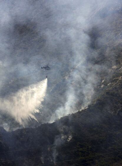 Un helicóptero del Infoca descarga agua sobre el incendio de Marbella.