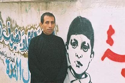 Yamal al Dura, junto a un <i>grafitti</i> en El Bureij de su hijo acribillado por el Ejército israelí en Gaza.