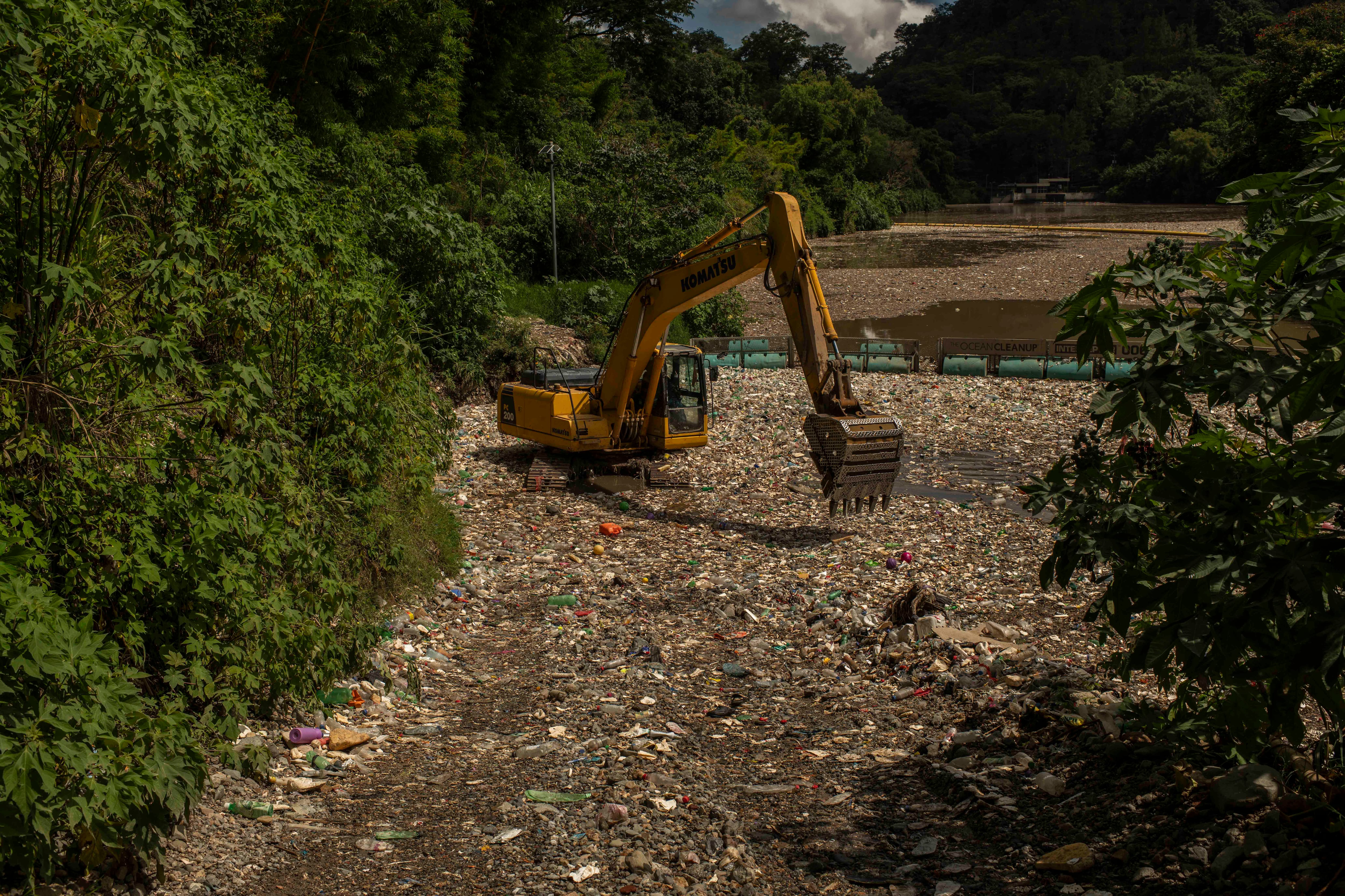 Una máquina excavadora trabaja en uno de interceptores de basura colocados en el río Las Vacas. 