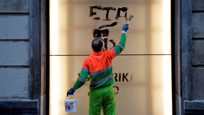 Un trabajador municipal limpia una pintada sobre ETA, en Bilbao.