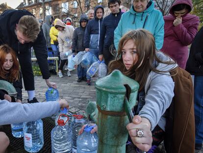 Varias personas llenan garrafas de agua en un parque de Kiev.