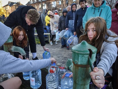 Varias personas llenan garrafas de agua en un parque de Kiev.