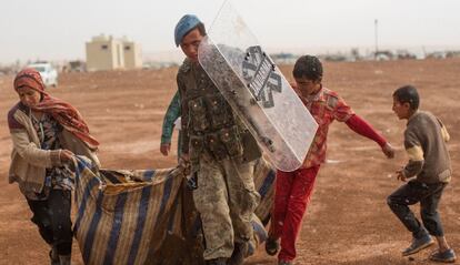 Un soldado turco, junto a refugiados sirios en Sanliurfa (Turquía), el 2 de octubre
