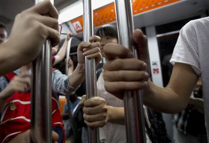 Las manos de pasajeros en un vagón del metro de Roma (Italia).