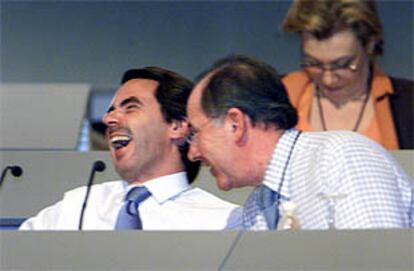 El presidente del Gobierno, Jóse María Aznar, se ríe en presencia del vicepresidente segundo y ministro de Economía, Rodrigo Rato.
