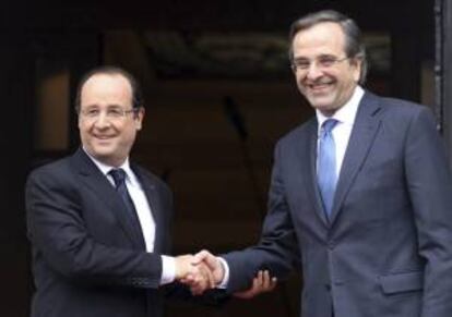 El primer ministro heleno, Antonis Samaras (dcha), estrecha la mano del presidente galo, François Hollande (izda), en Atenas (Grecia).