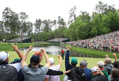 El público aplaude mientras Tiger Woods celebra su birdie en el verde 16 durante la ronda final del Masters de Augusta.