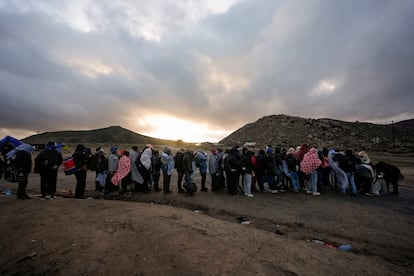 Migrantes que buscan asilo hacen fila en un campamento, en California, en 2024.