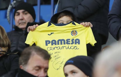 Un niño muestra una camiseta del Villarreal CF firmada.