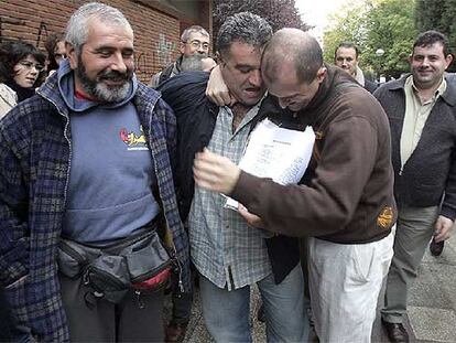Dos trabajadores de Caballito se abrazan emocionados, ayer, tras la firma del acuerdo con la empresa que ha puesto fin a los dos años de huelga.