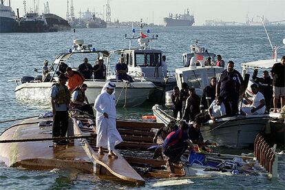 Trabajadores de emergencias inspeccionan los restos del barco hundido.