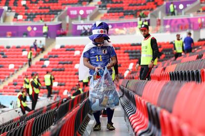 Aficionados de Japón recogen la basura de las gradas tras el partido de fútbol ante Costa Rica que han perdido por 0-1.