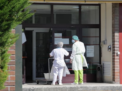 Dos trabajadores en la entrada de una residencia donde ha habido un brote, en Lugo.