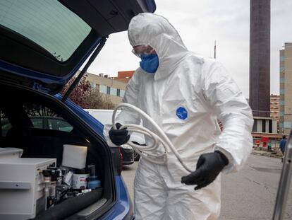 Un técnico protegido con un traje, guantes y mascarilla.