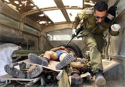 Un soldado israelí salta por encima de los cadáveres de tres palestinos en un camión. Los activistas fueron abatidos tras matar a cuatro soldados en Gaza.