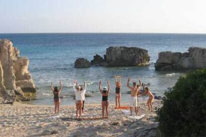 Ejercicio de pilates en una playa de Ibiza, organizado por Light Visions.