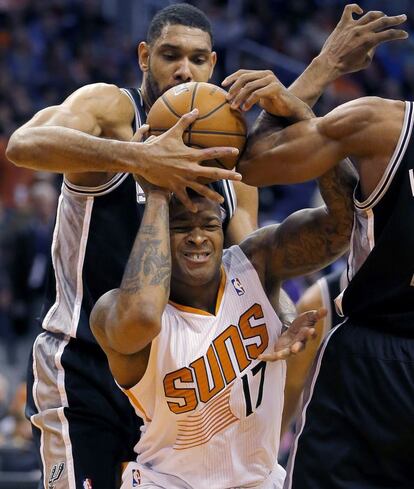 El jugador de los San Antonio Spurs, Tim Duncan trata de quitar el balón al jugadir de los Phoenix Suns PJ Tucker durante la segunda mitad del partido de baloncesto de la NBA que enfrentó a sus dos equipos.