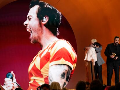 Harry Styles, left, embraces Kid Harpoon, center, while Tyler Johnson accepts the award for album of the year for 'Harry's House' at the 65th annual Grammy Awards on Sunday, Feb. 5, 2023, in Los Angeles.