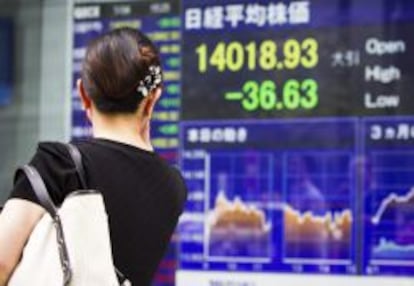 Una mujer observa una pantalla con los resultados de la bolsa de Tokio (Jap&oacute;n).