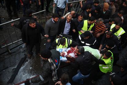 Una mujer es evacuada por personal sanitario tras la explosión de un coche bomba en Beirut (Líbano).